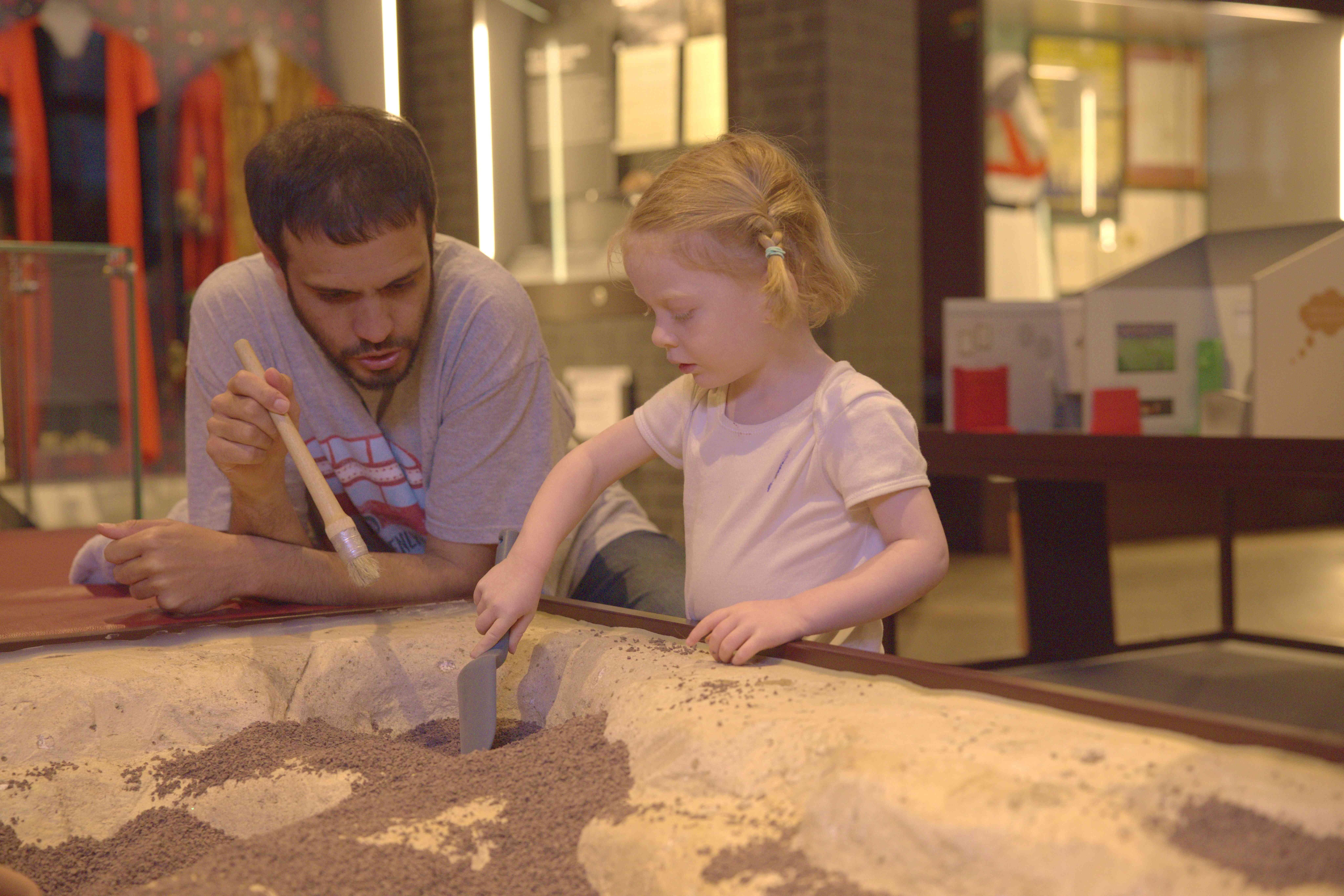 a man and a young girl enjoy hands on history at the Museum of Oxford