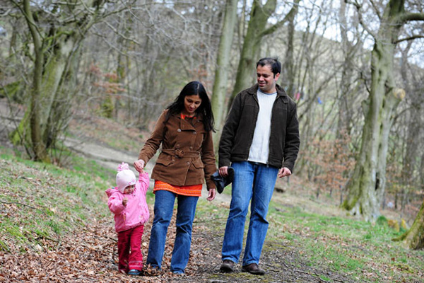 Family of three people walking in the woods