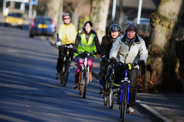 Group of people cycling on a road