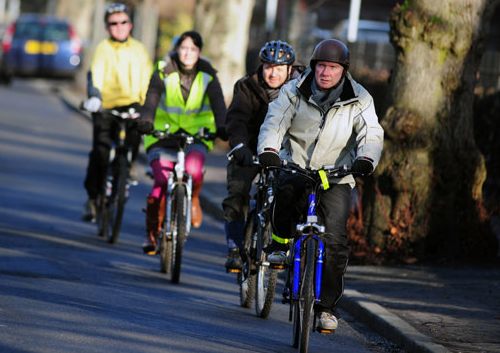 Four people cycling in a line