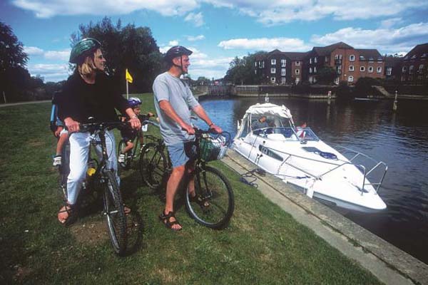 People on bicycles next to a river