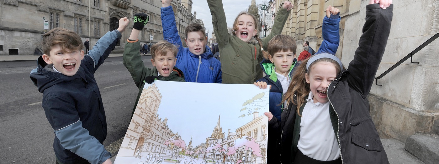 Image of Oxford schoolchildren in High Street holding up an image of what the road could look like when they're in their 40s.