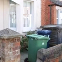 Example of correct bin presentation showing a green bin positioned close to the entrance so collection crews don't need to walk on to the property to collect it